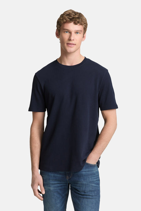 T-shirt bleu à manches courtes de TOM TAILOR, avec un motif côtelé fin, porté avec un jean et des baskets blanches.