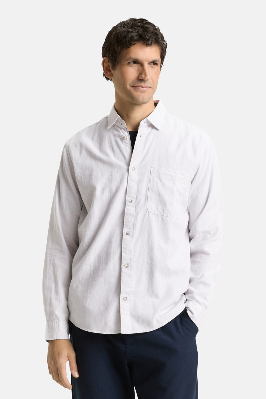 Man in wit overhemd en donkerblauwe broek.