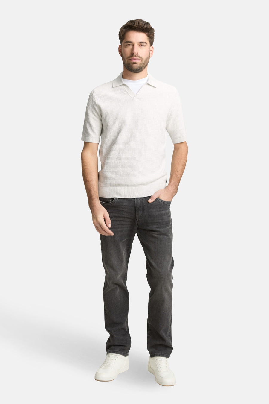 Ecru polo met korte mouwen van Tom Tailor, met een subtiele textuur en gecombineerd met donkere jeans en witte sneakers.