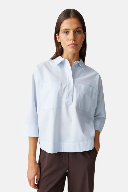 Chemisier bleu à manches courtes d'OPUS, avec deux poches poitrine et pantalon marron.