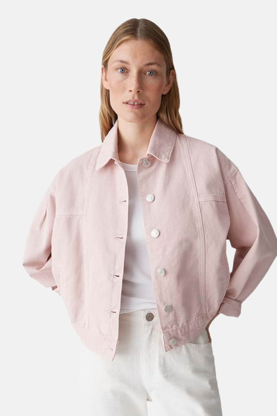 Veste en jean rose d'OPUS, vue de côté, associée à un pantalon blanc.