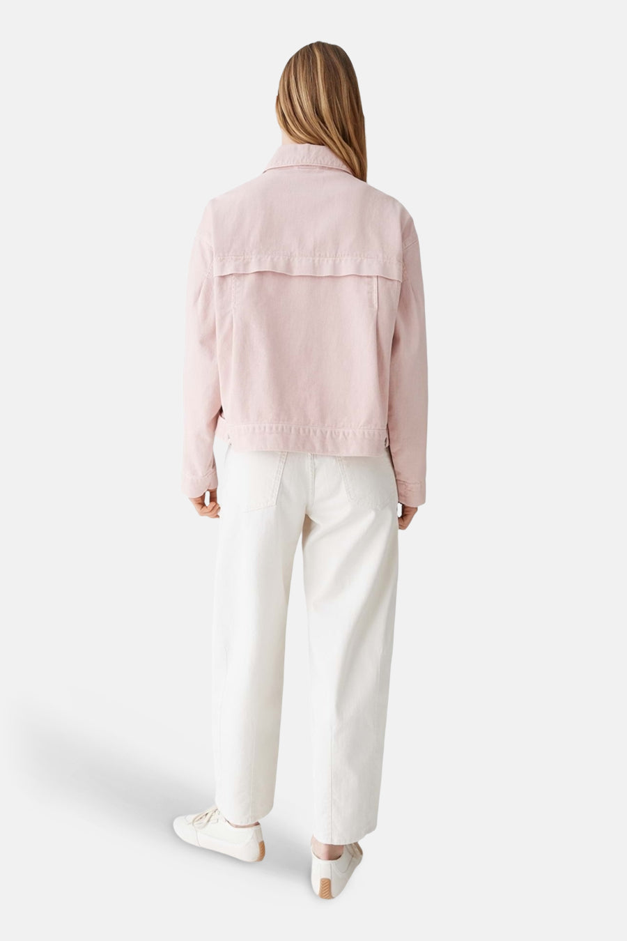 Roze jeansjas van OPUS, gezien van achteren, gecombineerd met een witte broek en sneakers.
