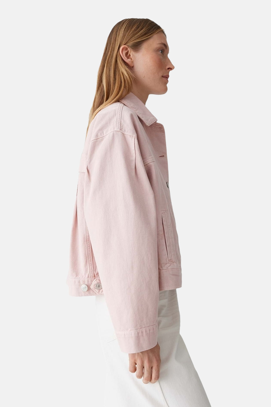 Roze jeansjas van OPUS, gezien vanaf de zijkant, gecombineerd met een witte broek.