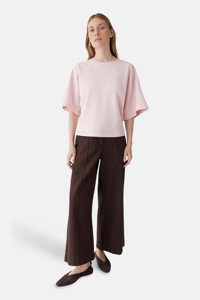 Roze sweater met ronde hals van OPUS, met wijde mouwen, gecombineerd met bruine broek en schoenen.