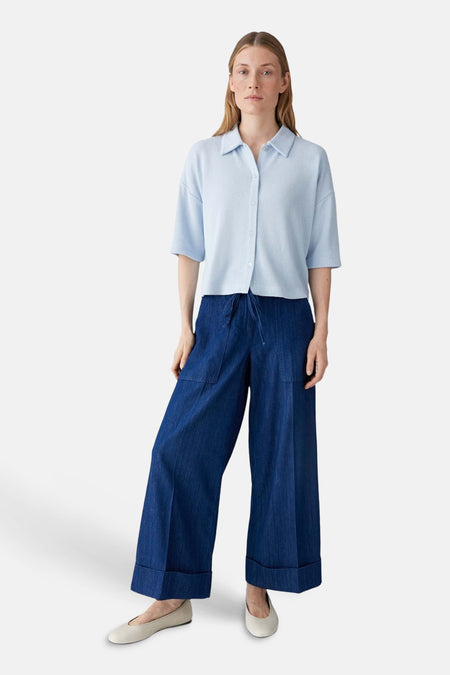 Blauw gilet van OPUS, gedragen met een lichtblauw poloshirt en wijde donkerblauwe broek met omslag.
