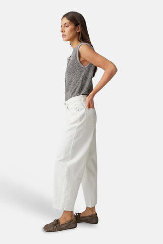 Jean en denim blanc cassé coupe spéciale OPUS avec jambes larges et plus courtes, porté avec un haut gris et des mocassins marron, vue de côté.
