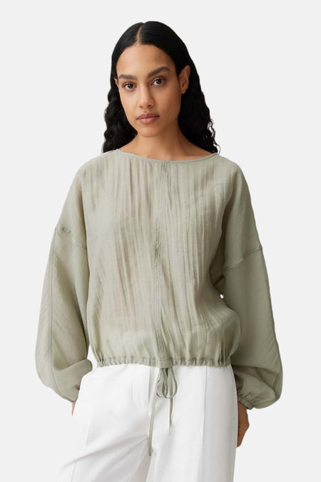 Chemisier vert à manches longues d'OPUS, avec des plis sur le devant et un cordon de serrage en bas.