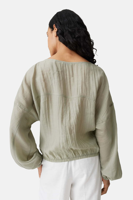 Groene blouse met lange mouwen van OPUS, met een textuur en een elastische band aan de onderkant, op de rug gezien.
