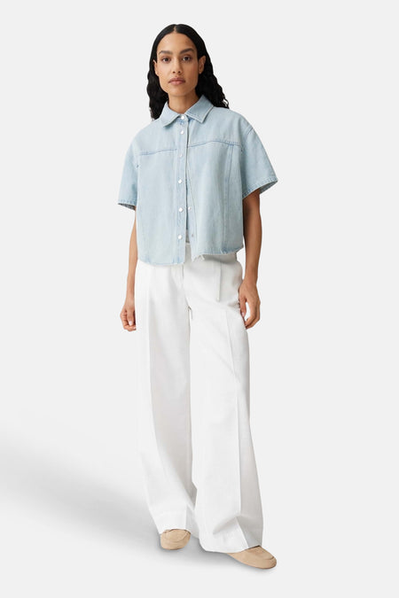 Ecru broek van OPUS met wijde pijpen, gestyled met een lichtblauwe spijkerblouse en beige loafers.