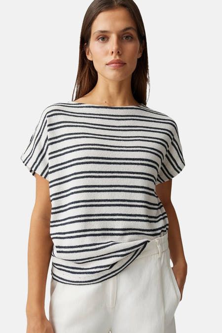 T-shirt blanc à rayures noires OPUS, en tissu éponge, à manches courtes, porté sur un pantalon blanc.