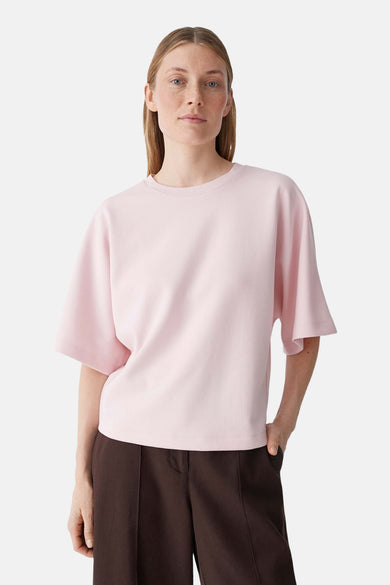 T-shirt rose OPUS coupe ample, manches larges jusqu'au coude et col rond, vu de dos, combiné avec un pantalon marron.
