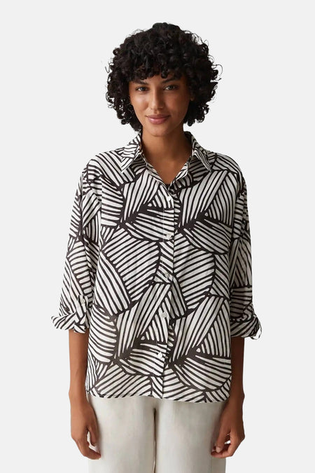 Chemise à manches longues OPUS, à motif rayé abstrait noir et blanc, manches retroussées, portée avec un pantalon clair, vue arrière.
