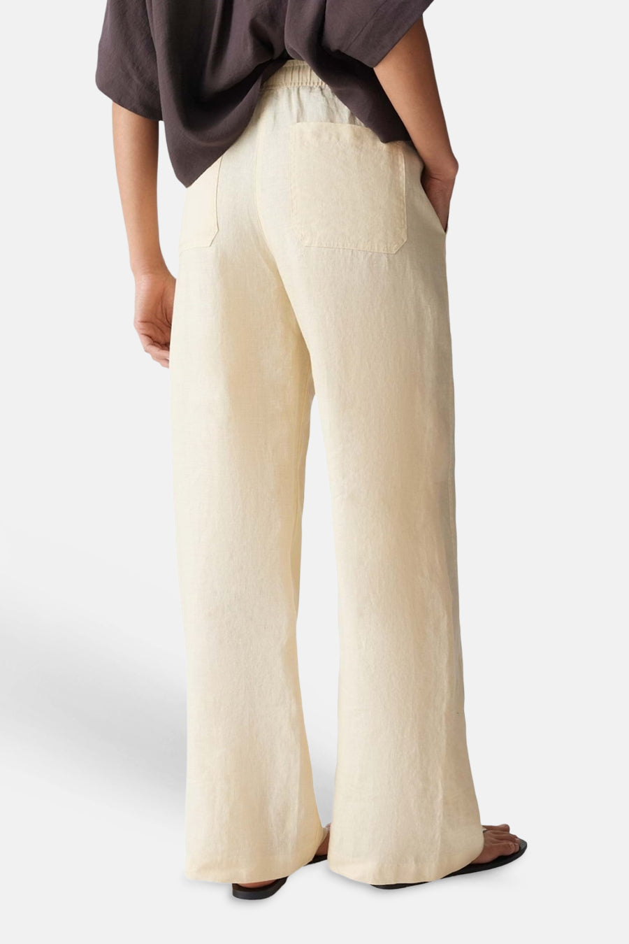 Lichtgele dames seizoensbroek van OPUS met elastische taille, wijde pijpen en achterzakken, vanuit de rug gezien.