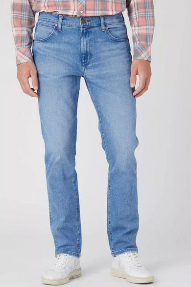 Jean tapered bleu clair de Wrangler, avec un motif à points sur les poches arrière et une patch en cuir.