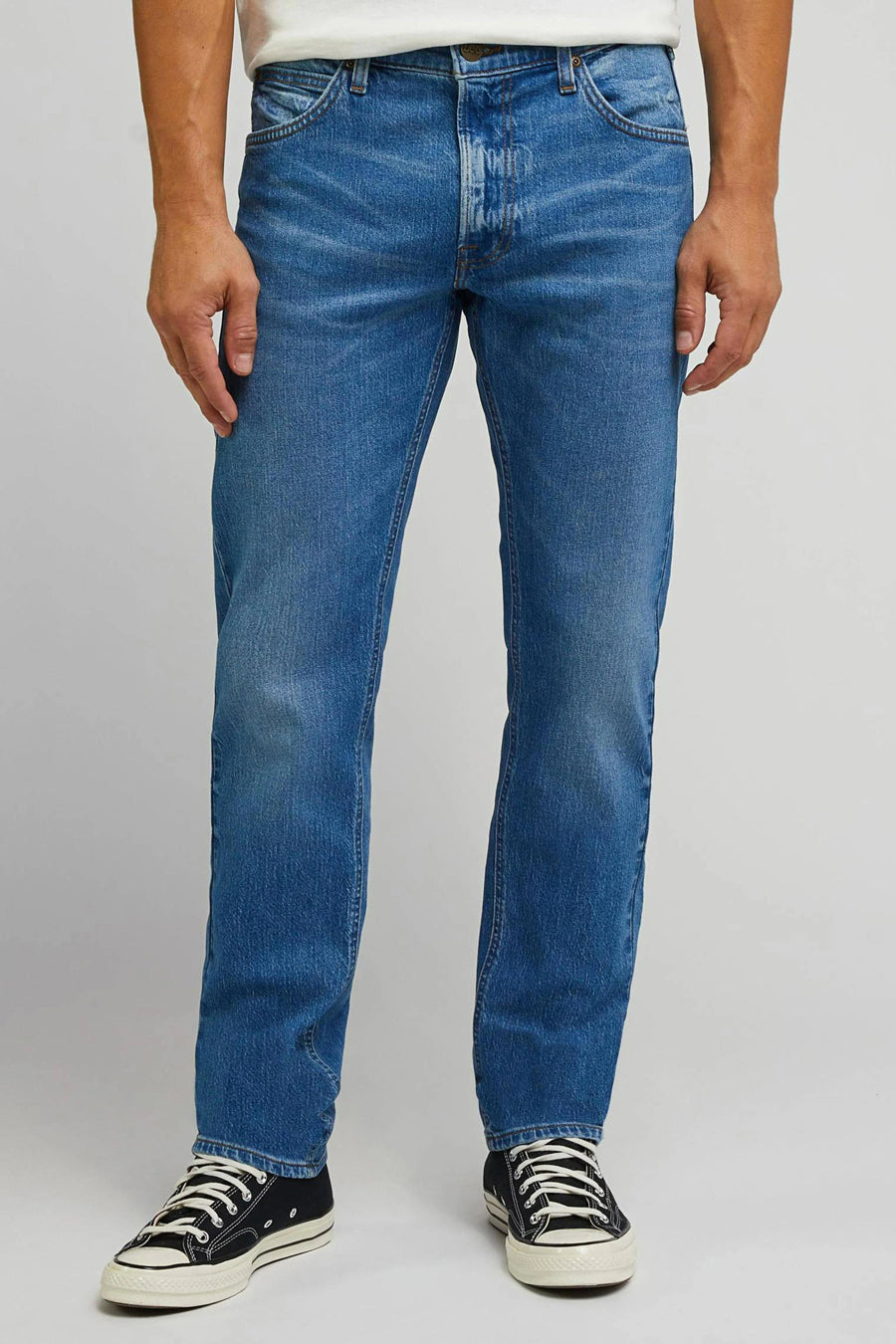Jean droit en denim bleu de Lee®, vu de l'arrière, avec des baskets sombres.