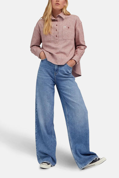 Jean denim bleu clair Stella A-ligne de Lee®, avec des jambes larges et des chaussures noires.