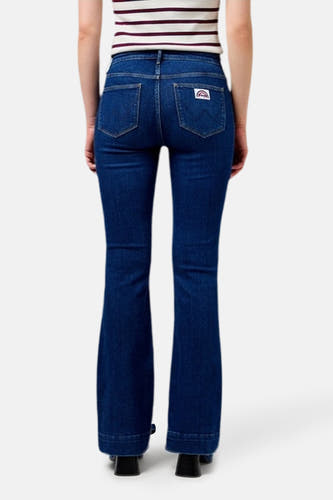 Donkerblauwe flared jeans van Wrangler®, gezien van achteren, met een regenbooglogo op de achterzak en hakken.