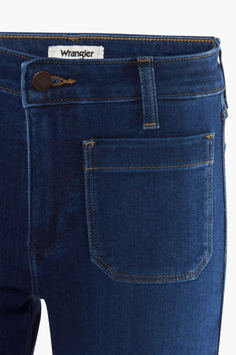 Jean flare bleu marine de Wrangler, avec une poche brodée et des surs brun.