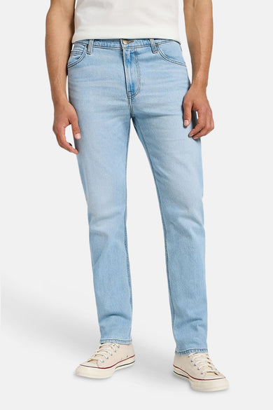 Lichtblauwe rechte jeans van Lee, met klassieke styling en gedragen met crèmekleurige canvas schoenen.
