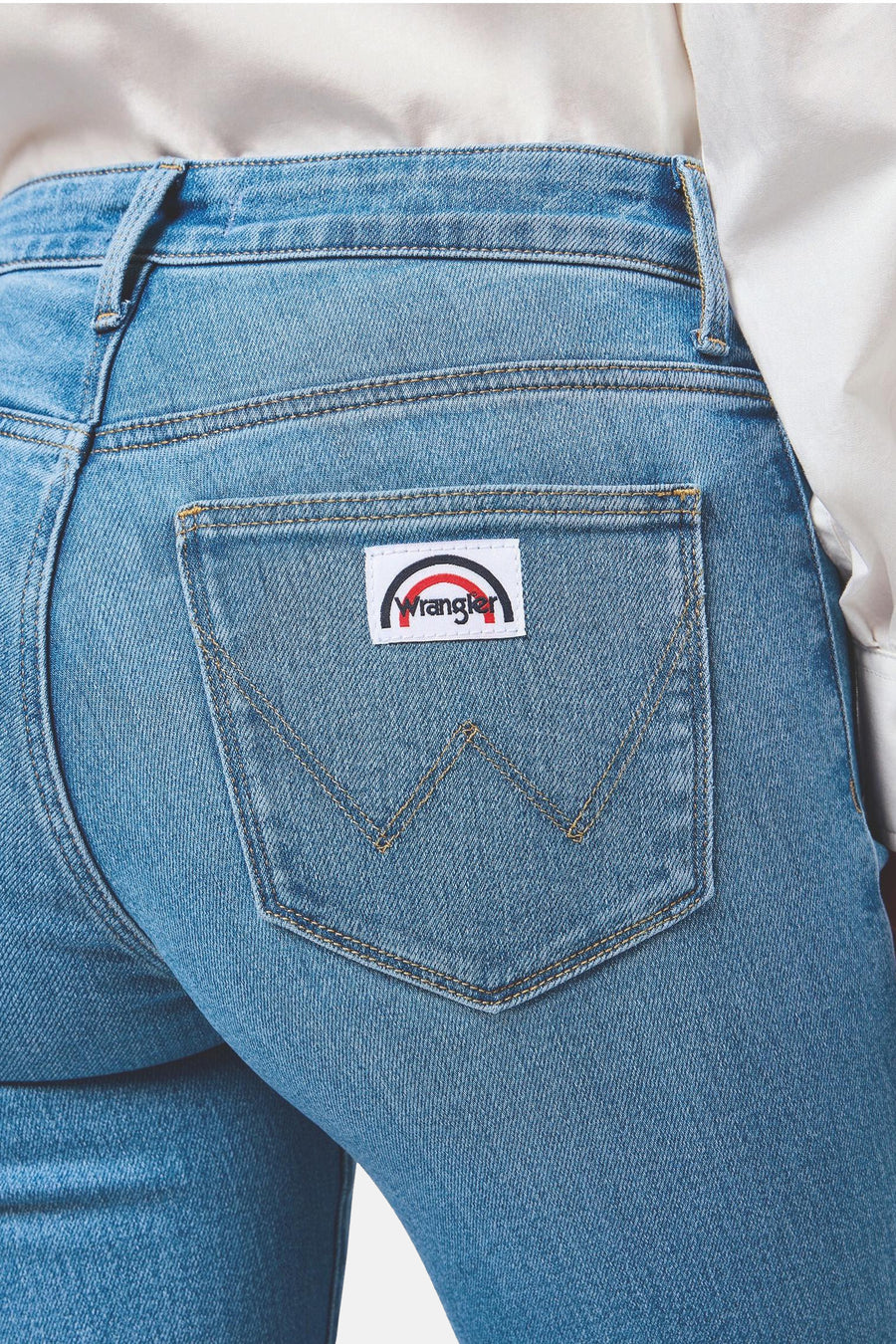 Lichtblauwe denim uitlopende jeans van Wrangler, achterkant met logopatch en iconische 'W'-stiksels op de zak.