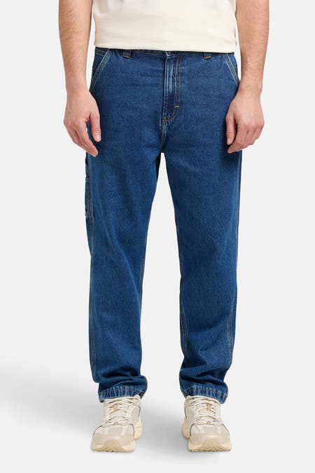 Jean droit en denim bleu de Lee®, associé à des baskets crème et un T-shirt blanc.