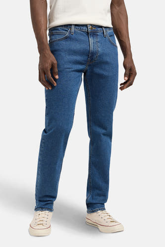 Jean droit en denim bleu de Lee, avec des chaussures légèrement colorées et un T-shirt blanc.