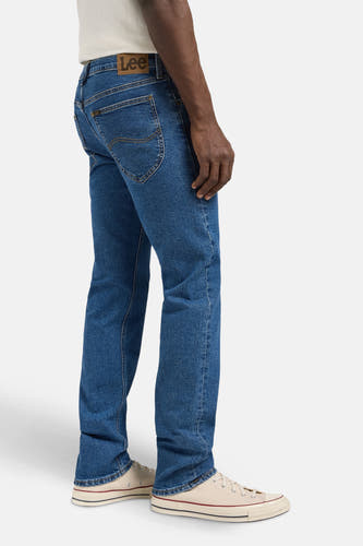 Jean droit de denim bleu de Lee, avec des surpiqures sur les poches arrière et des baskets en coton.