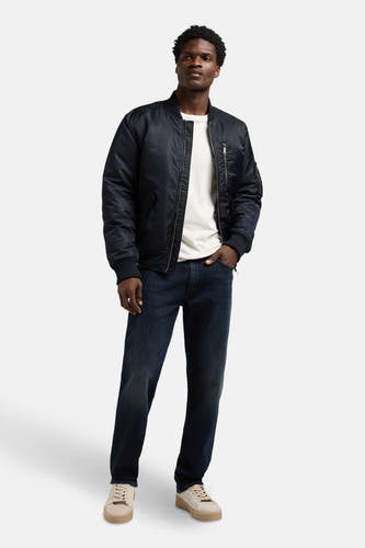 Jean droit bleu marine en denim de Lee®, associé à un t-shirt blanc et une veste bomber bleu foncé.