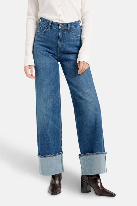 Jean large bleu de Lee, avec revers et poches arrière, combiné avec un pull blanc.