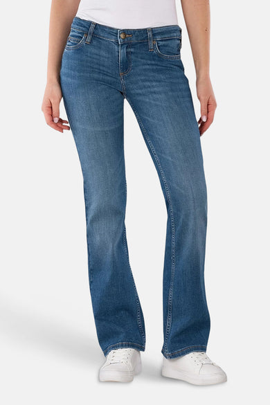 Jean bootcut bleu moyen de Lee, avec des poches arrière ornées et des chaussures blanches.
