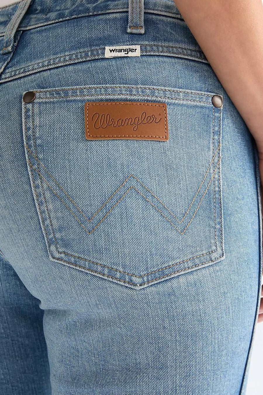 Jean évasé denim bleu moyen de Wrangler, avec un motif W brodé et un patch de marque en cuir à l'arrière.