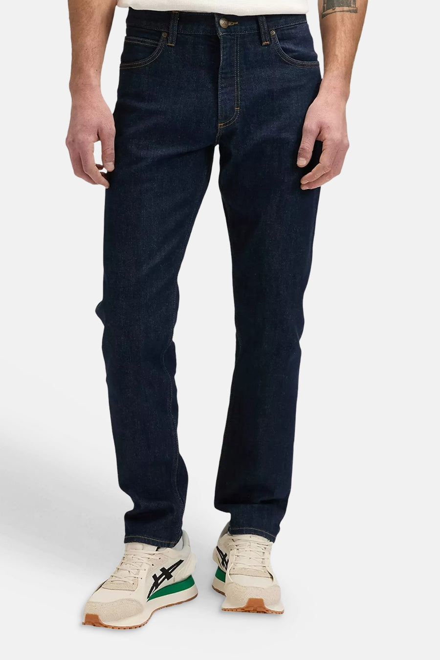 Donkerblauwe tapered jeans van Lee®, met klassieke vijfzakkenstijl en subtiele slijtage, vooraanzicht op model met witte sneakers.