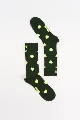 Chaussettes vertes de Happy Socks avec un imprimé cœur jaune clair sur un fond blanc.