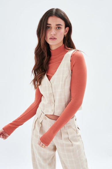 Blazer écru de 24 couleurs avec motif à carreaux, porté sur un pull orange manches longues.
