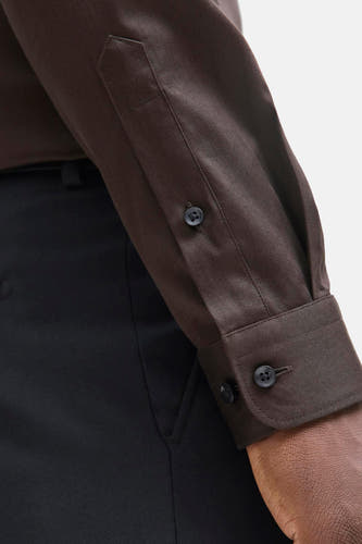 Chemise brune à manches longues de PREMIUM by JACK & JONES, avec des détails de boutons sur les poignets et un pantalon noir.