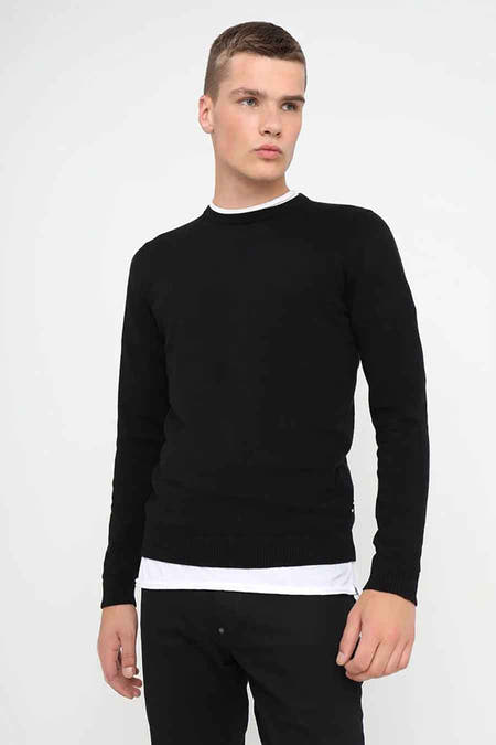Sweat-shirt noir à col rond de CORE BY JACK & JONES, avec des manches longues, porté avec un shirt blanc et un pantalon noir.