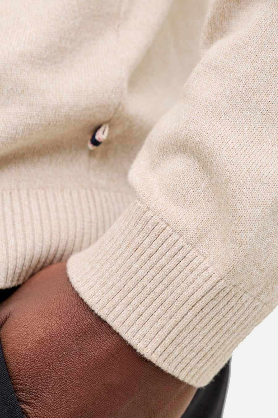 Beige gebreide trui mouw met geribde boord.
