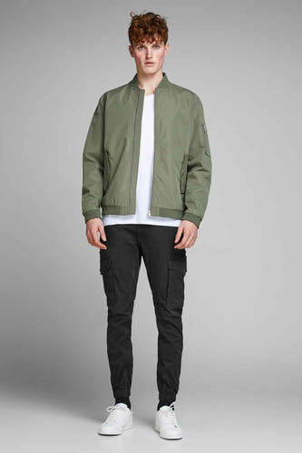 Jean cargo noir de JACK & JONES JEANS INTELLIGENCE, avec des poches et des baskets blanches.