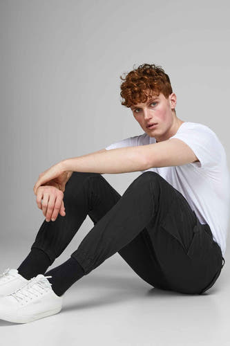 Jean cargo noir de JACK & JONES JEANS INTELLIGENCE, porté avec un T-shirt blanc et des baskets blanches.