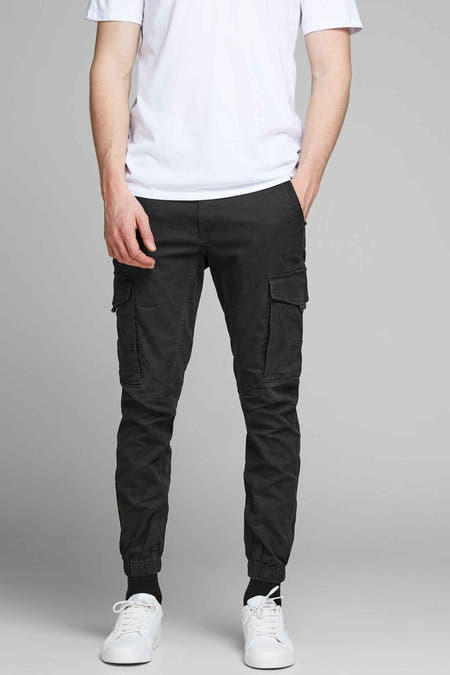 Jean cargo noir de JACK & JONES JEANS INTELLIGENCE, avec des poches brodées et des baskets blanches.