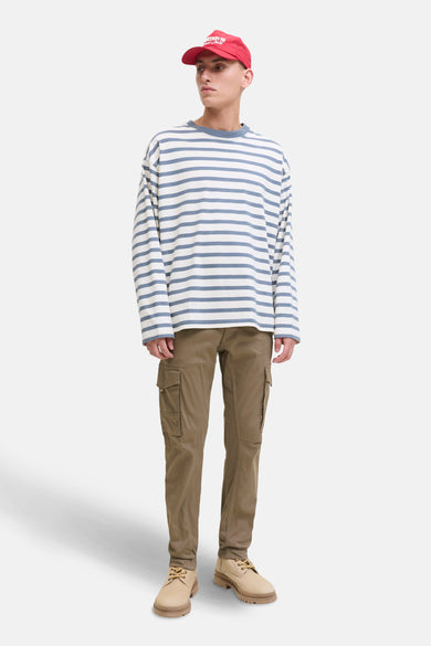 Pantalon de travail brun de JACK & JONES JEANS INTELLIGENCE, avec des poches, associé à un t-shirt rayé et des chaussures crème.