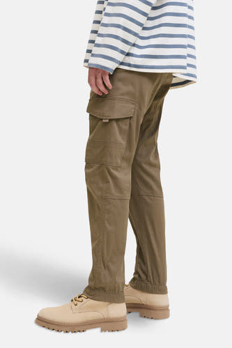 Pantalon cargo brun de JACK & JONES JEANS INTELLIGENCE, avec des poches sur les côtés, associé à des chaussures beige et un t-shirt rayé.