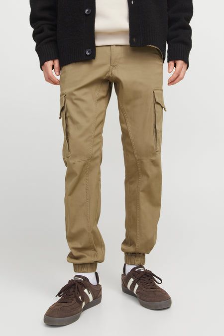 Jean cargo brun de JACK & JONES JEANS INTELLIGENCE, avec des poches sur les jambes et des chaussures brunes.