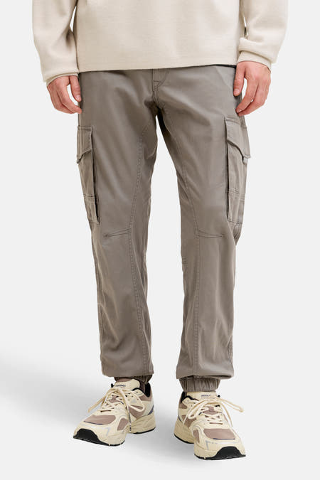 Pantalon de travail brun de JACK & JONES JEANS INTELLIGENCE, avec des poches cargo et des baskets beige.