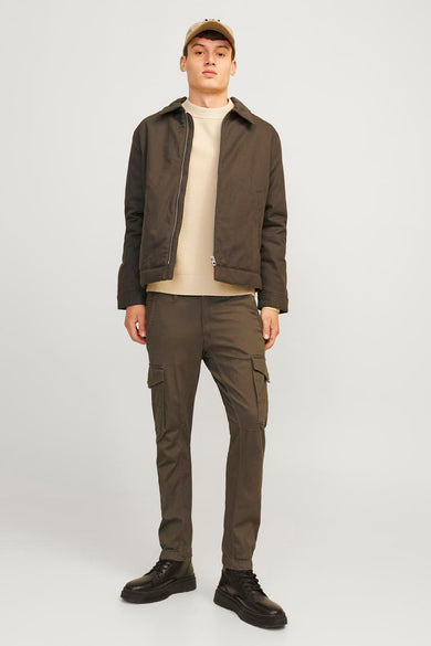 Pantalon de travail brun JACK & JONES JEANS INTELLIGENCE, porté avec un pull crème et une veste brune.