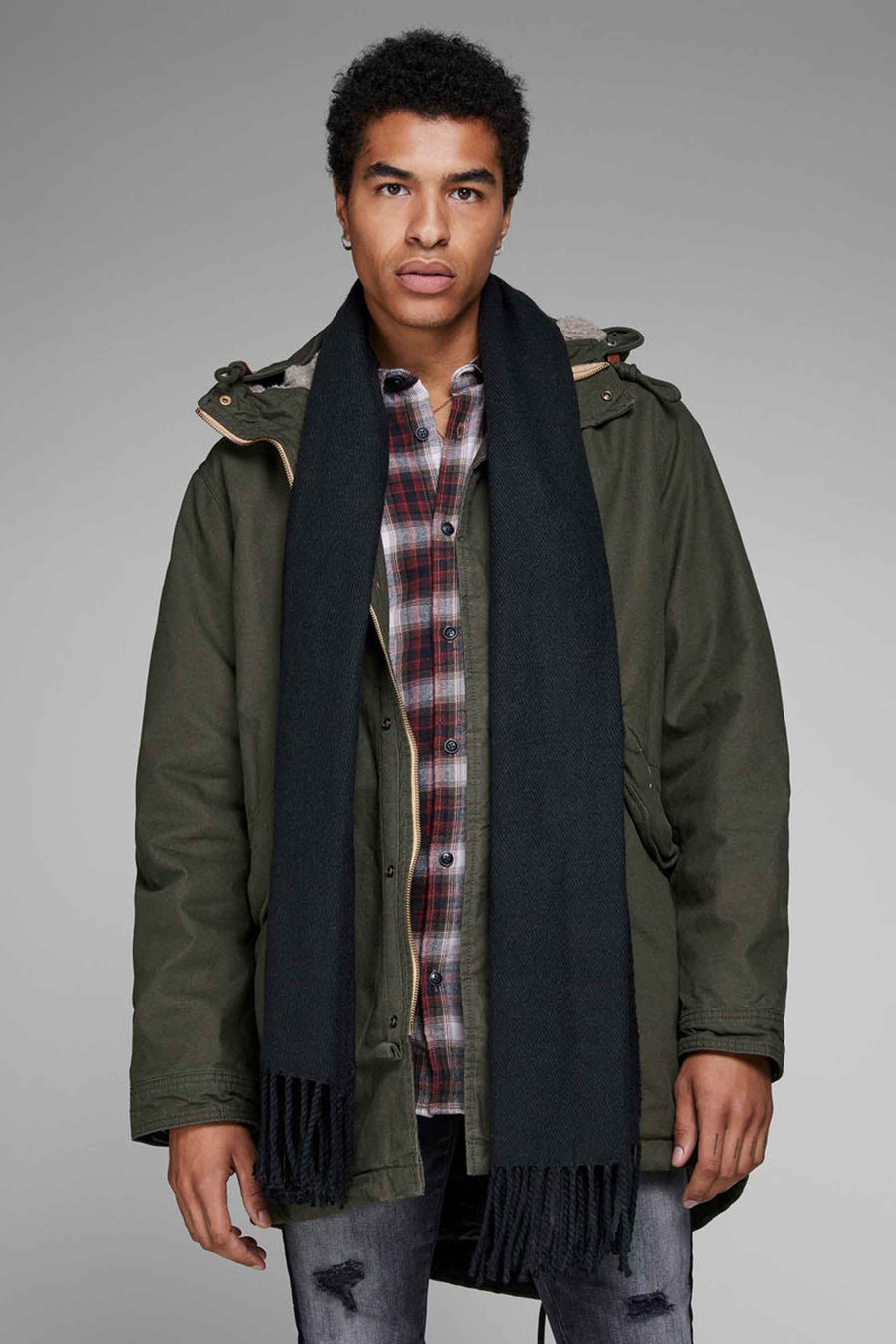 Chapeau d'hiver noir d'ACCESSORIES BY JACK & JONES, porté avec des franges sur une parka verte et un chemisier à carreaux.