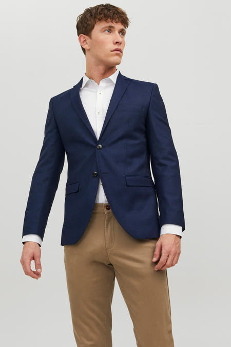 Blazer bleu de PREMIUM par JACK & JONES, dos nué, associé à un pantalon marron et des chaussures foncées.