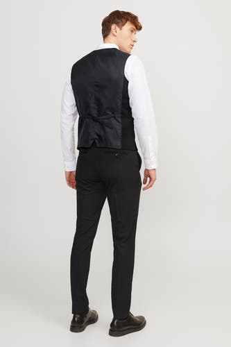 Gilet noir de PREMIUM par JACK & JONES, avec une ceinture réglable, porté sur un chemise blanc et un pantalon noir.