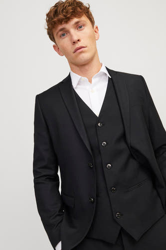 Gilet noir de PREMIUM par JACK & JONES, porté avec un chemisier blanc et un collier noir.