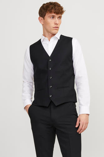 Gilet noir de PREMIUM par JACK & JONES, porté avec un chemisier blanc et un pantalon noir.